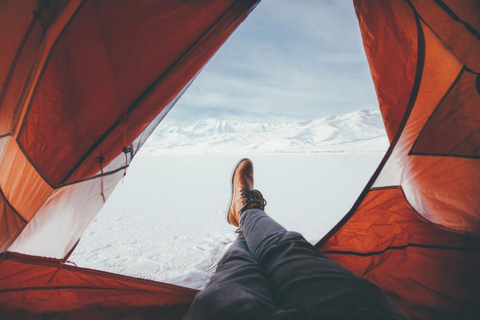 Free Image of Person Standing Inside Tent on Snow Covered Ground 