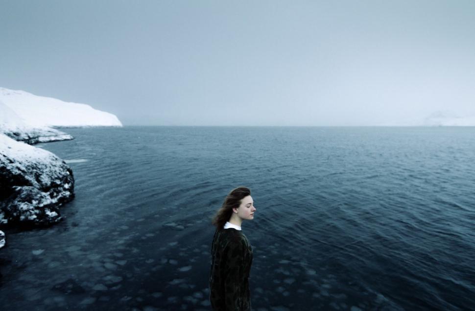 Free Image of Woman Standing in Middle of Body of Water 