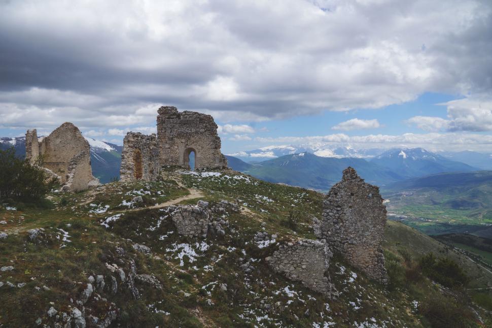 Free Image of Castle Atop Mountain Beneath Cloudy Sky 