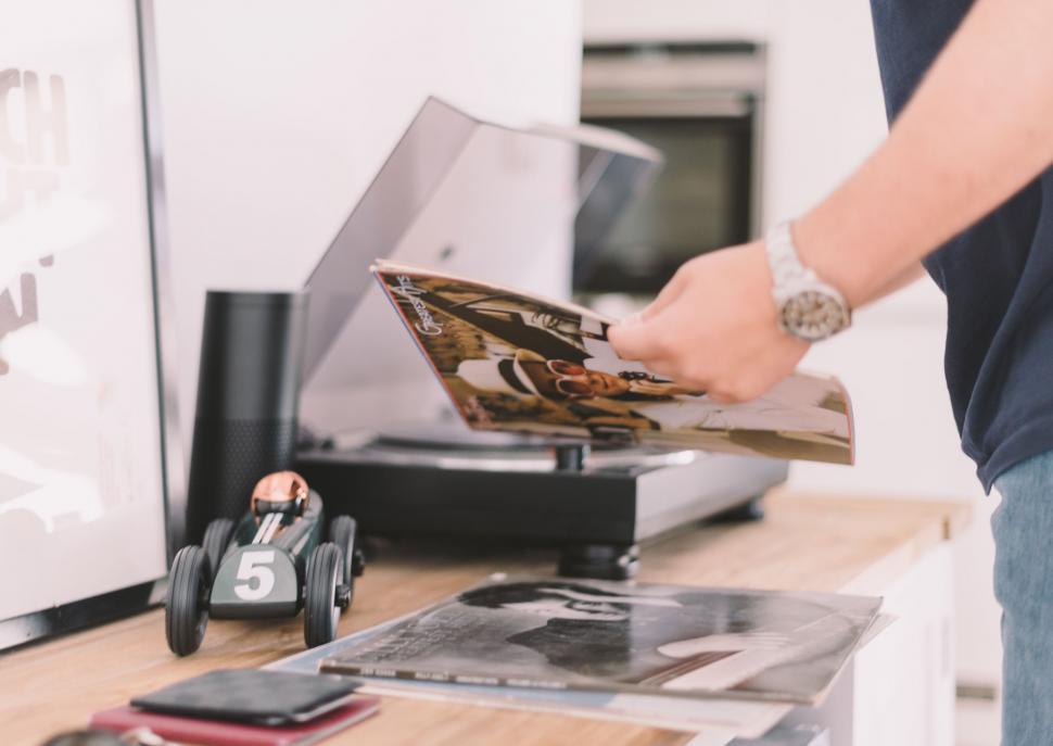 Free Image of Person Holding Magazine Over Table 