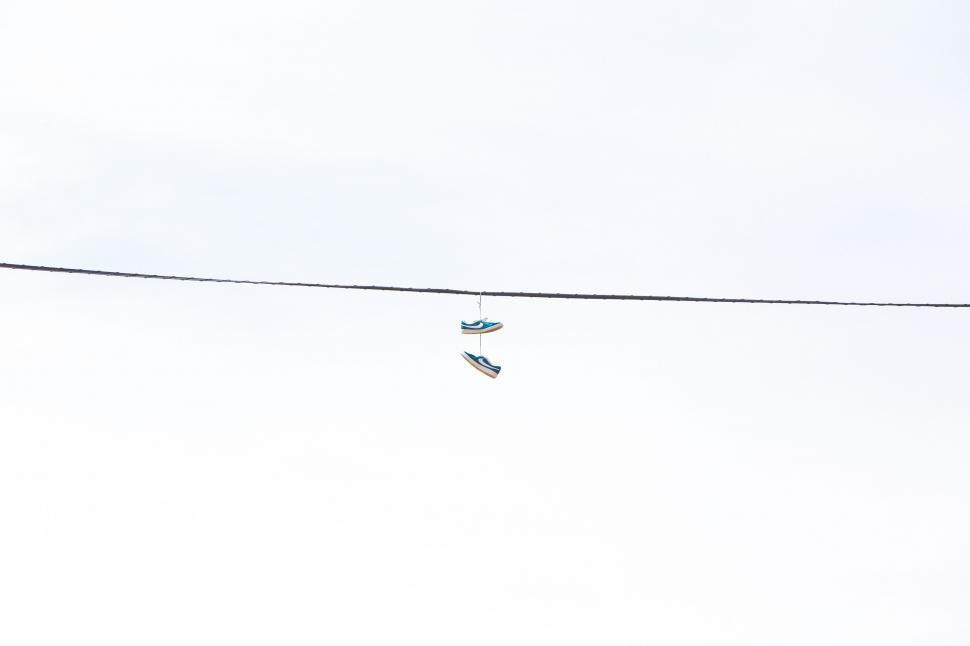 Free Image of Pair of Shoes Hanging From Wire 