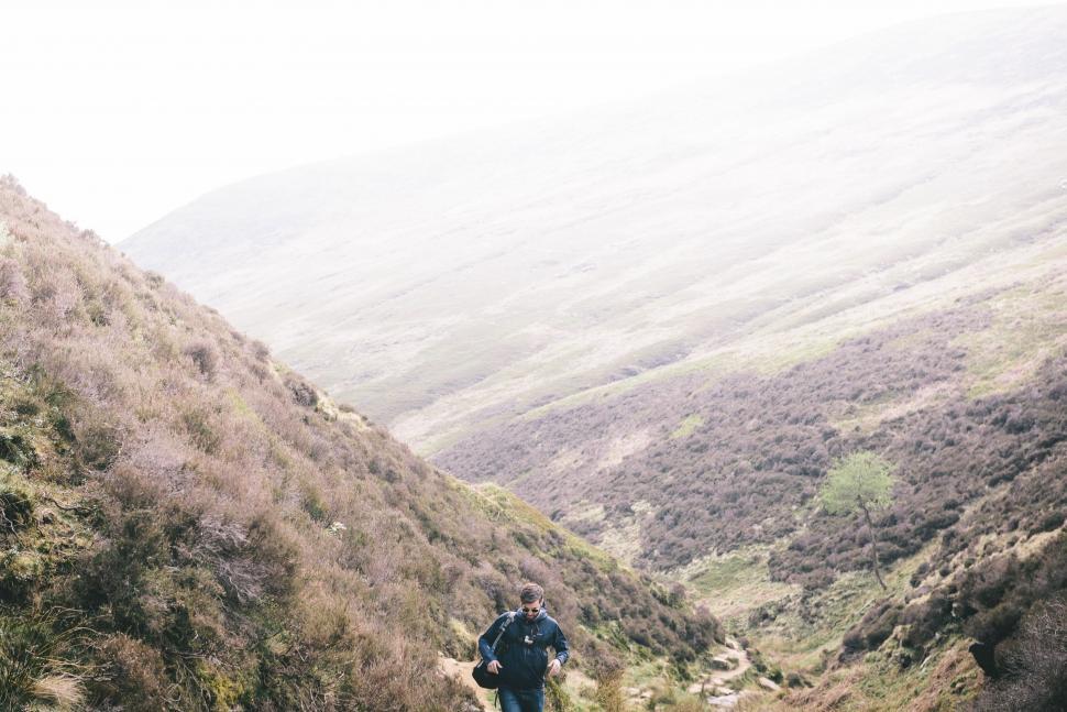 Free Image of Man Hiking Up Hill in Mountains 