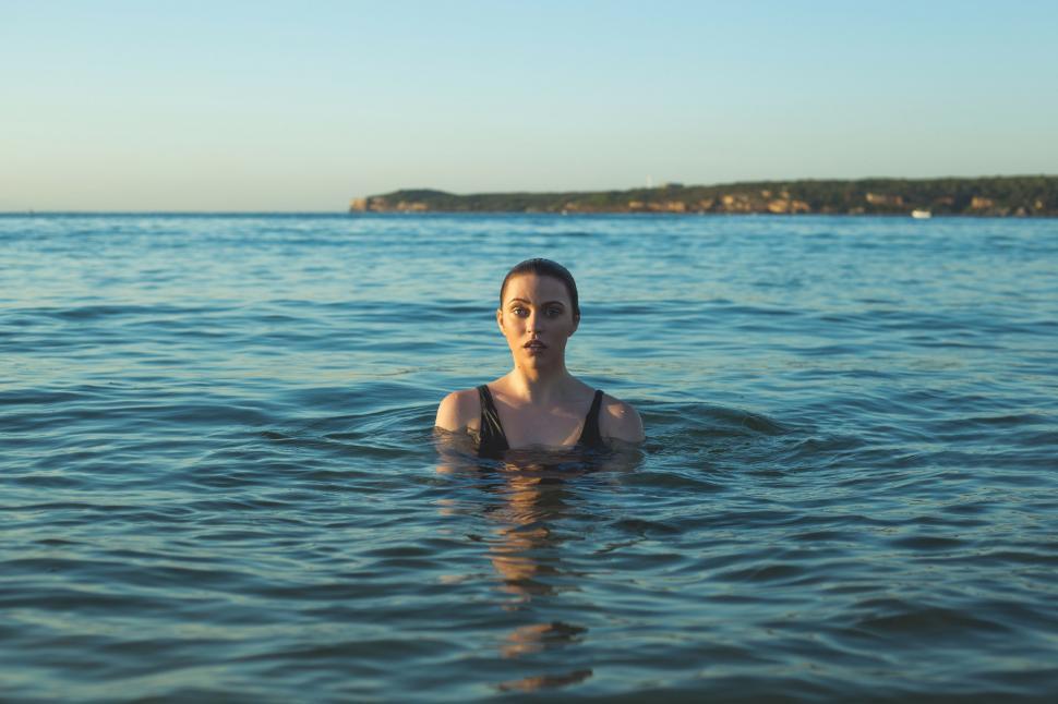 Free Image of Woman Standing in the Middle of Body of Water 