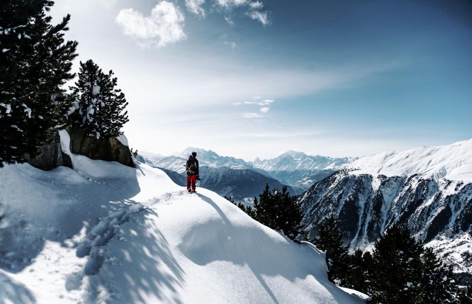 Free Image of Person Standing on Top of Snow Covered Mountain 