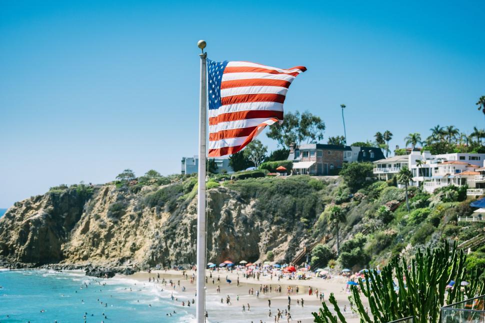 Free Image of American Flag Flying on a Beach Near the Ocean 