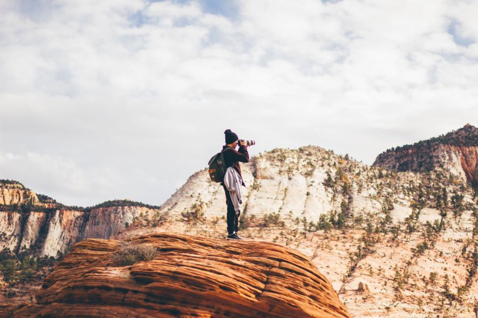 Free Image of Man Standing on Top of Red Rock 