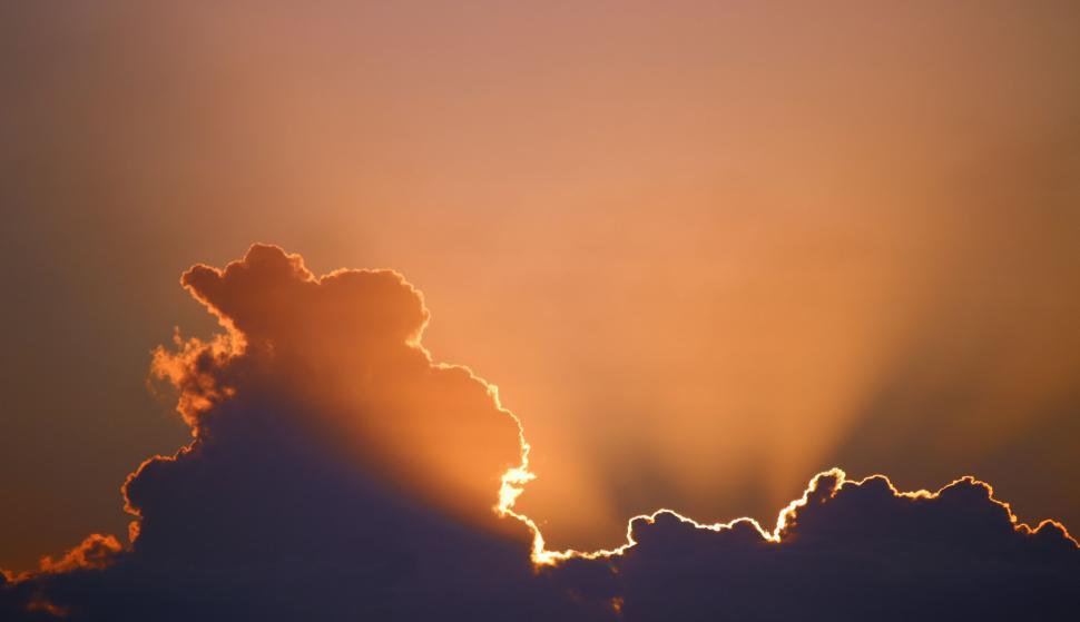 Free Image of Sun Setting Behind Cloud in Sky 