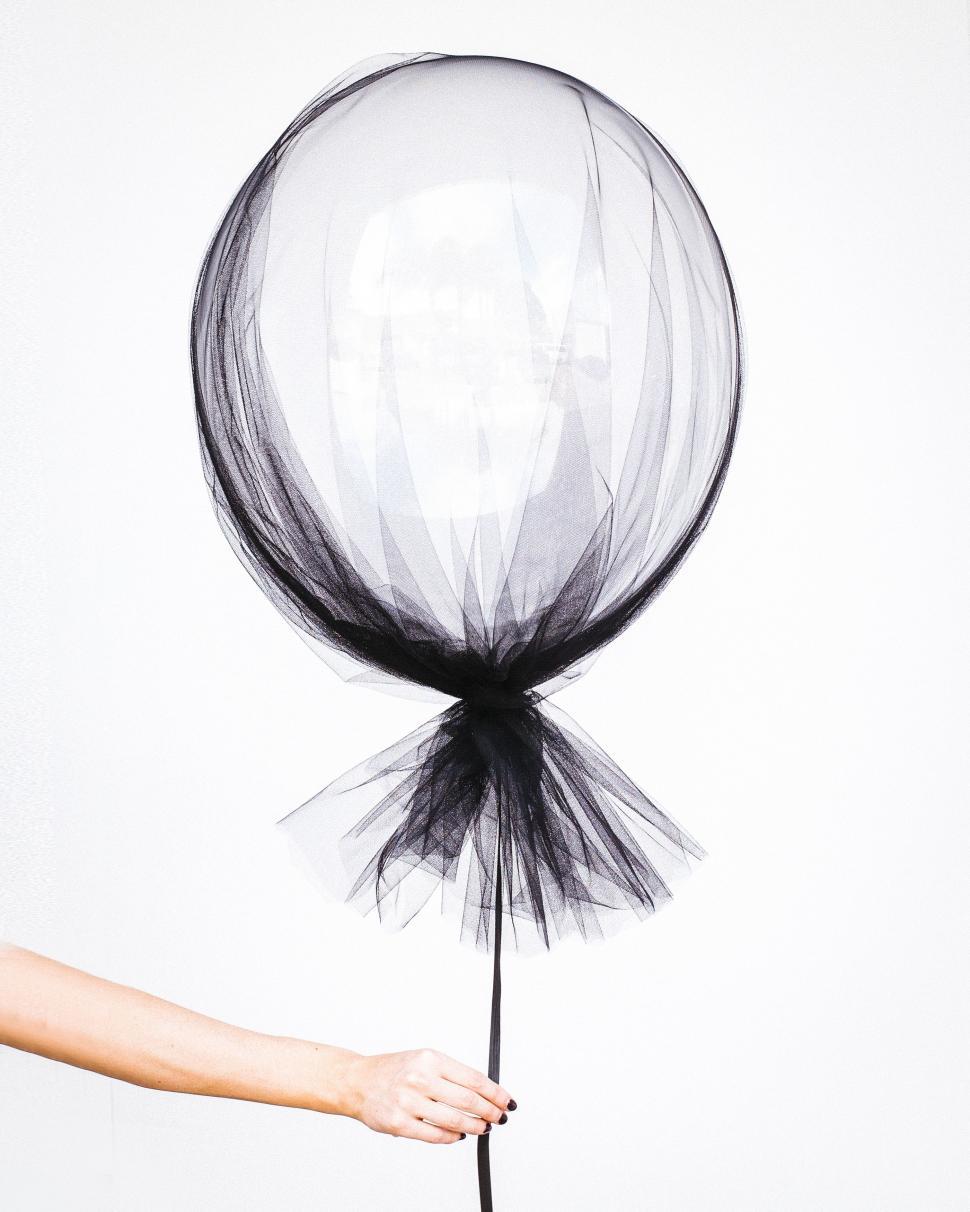 Free Image of Person Holding Black and White Balloon 