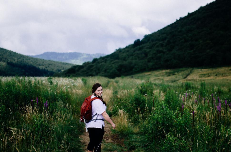 Free Image of Woman Walking Through Field With Backpack 
