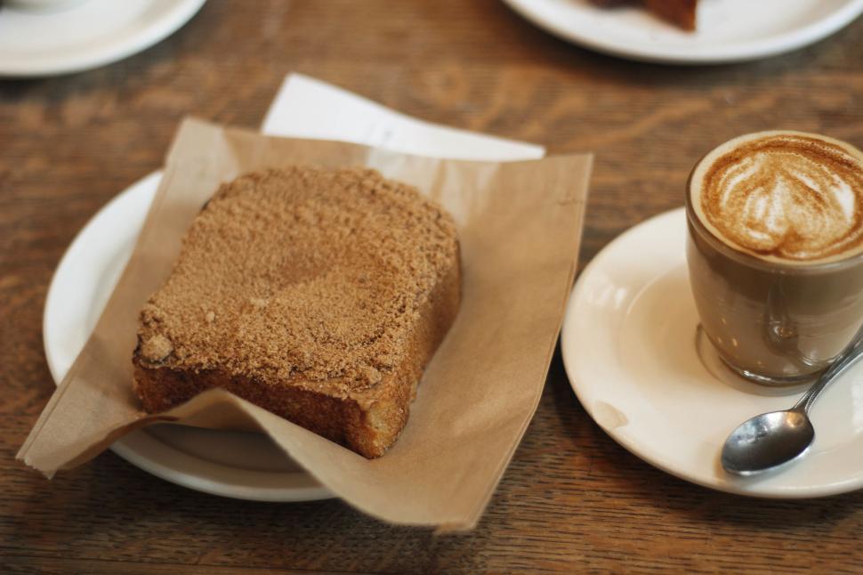Free Image of A Piece of Bread and a Cup of Coffee on a Table 