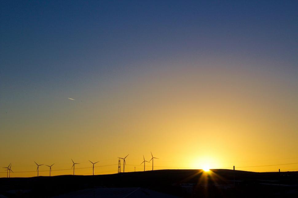 Free Image of Sun Setting Over Field of Windmills 