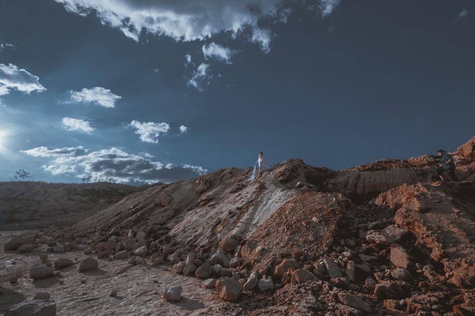 Free Image of Man Standing on Top of Pile of Rocks 