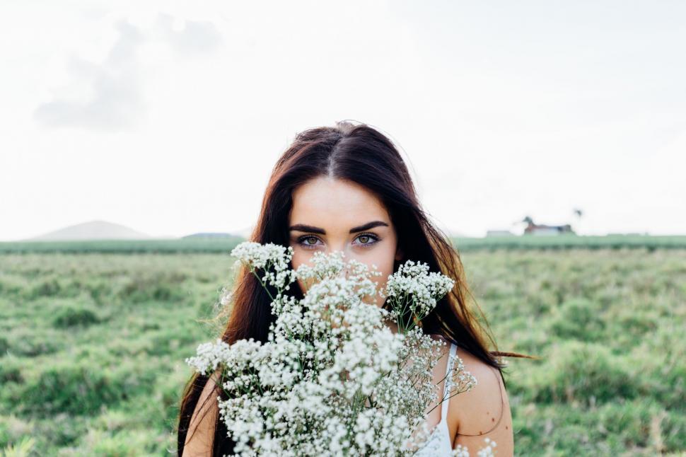 Free Image of Woman Holding Bunch of Flowers in Field 