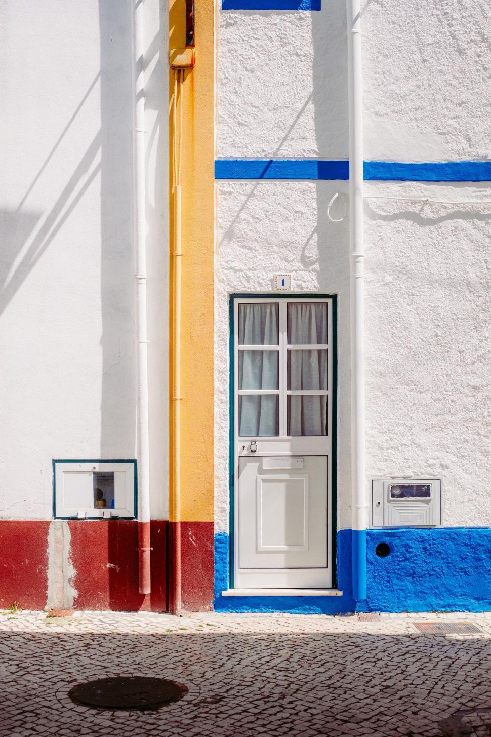 Free Image of White and Blue Building With Door and Window 