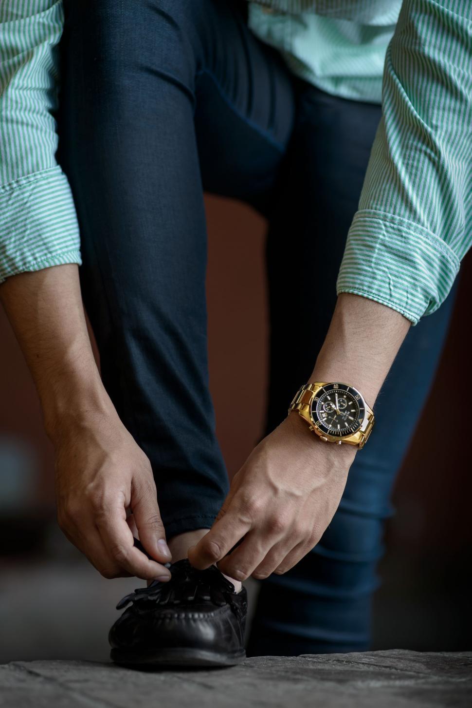 Free Image of Man Tying Shoes With Watch on Wrist 
