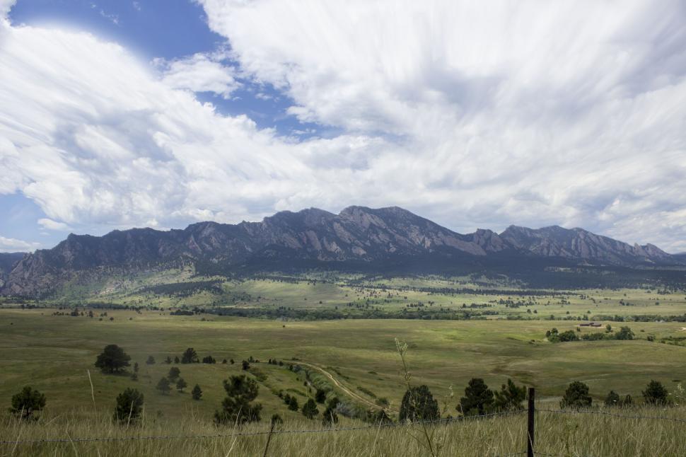 Free Image of Wide Open Field With Mountains in Background 