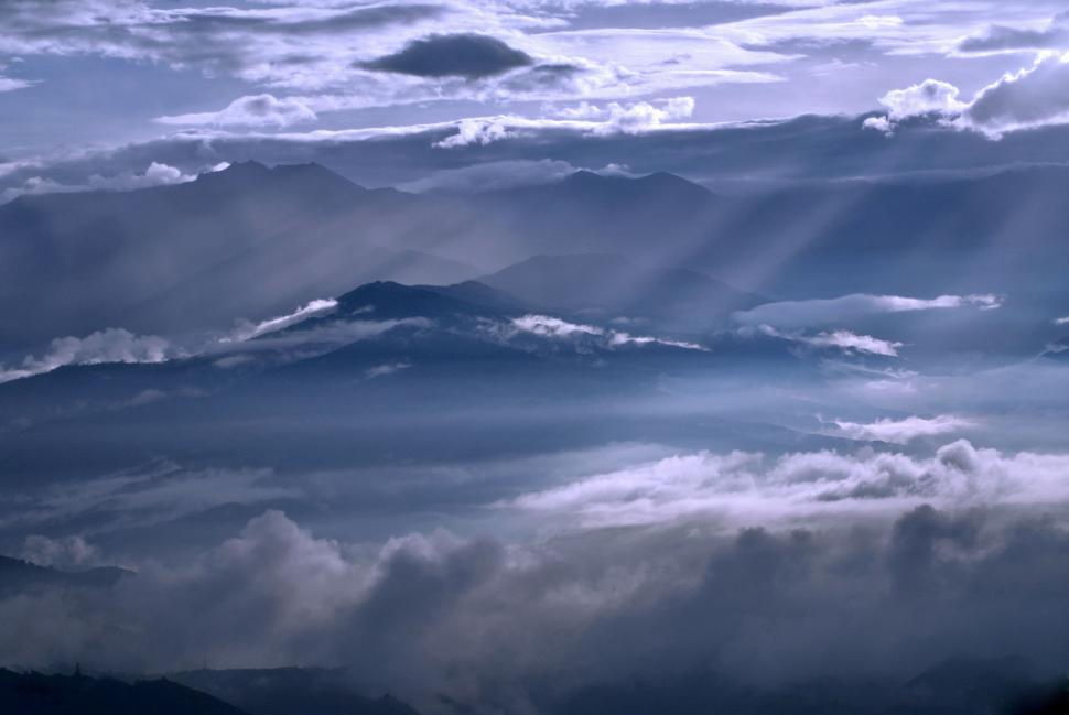 Free Image of Sun Shines Through Clouds Over Mountains 