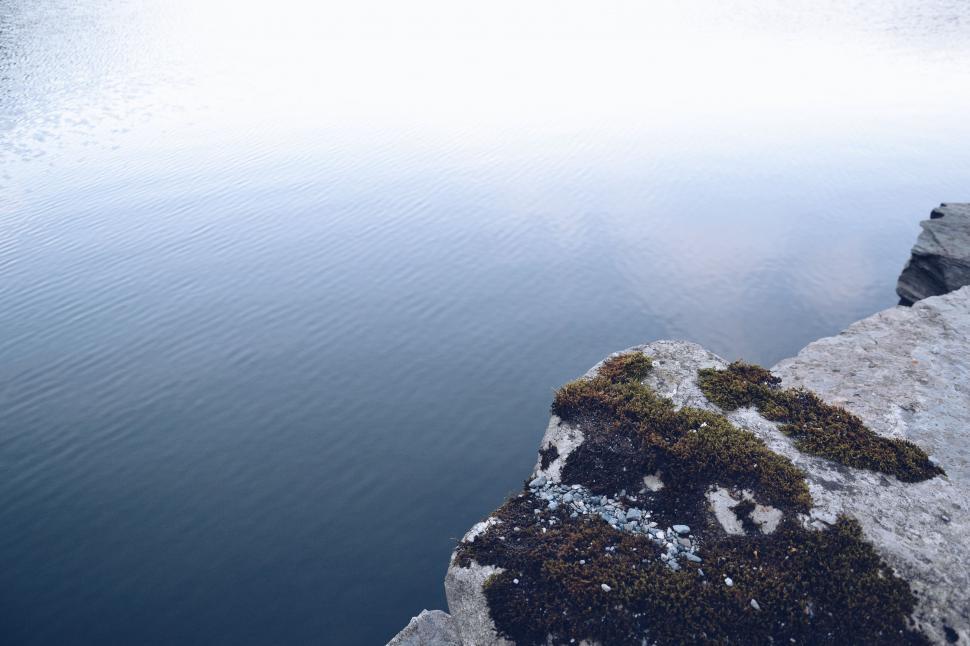 Free Image of Snow Covered Rocks Surrounding Body of Water 