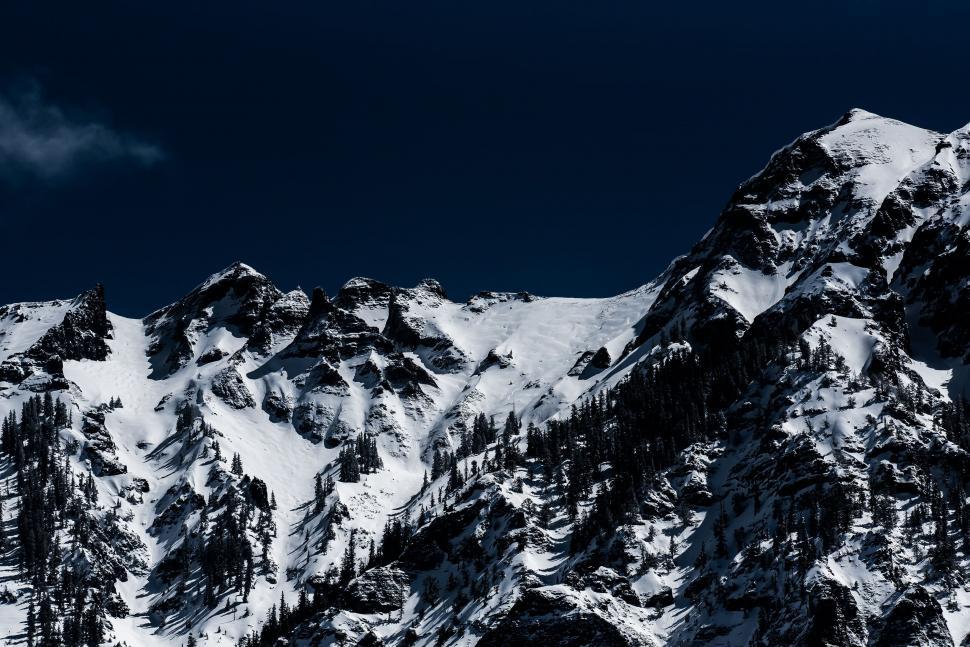 Free Image of Majestic Snow-covered Mountain Under Dark Sky 