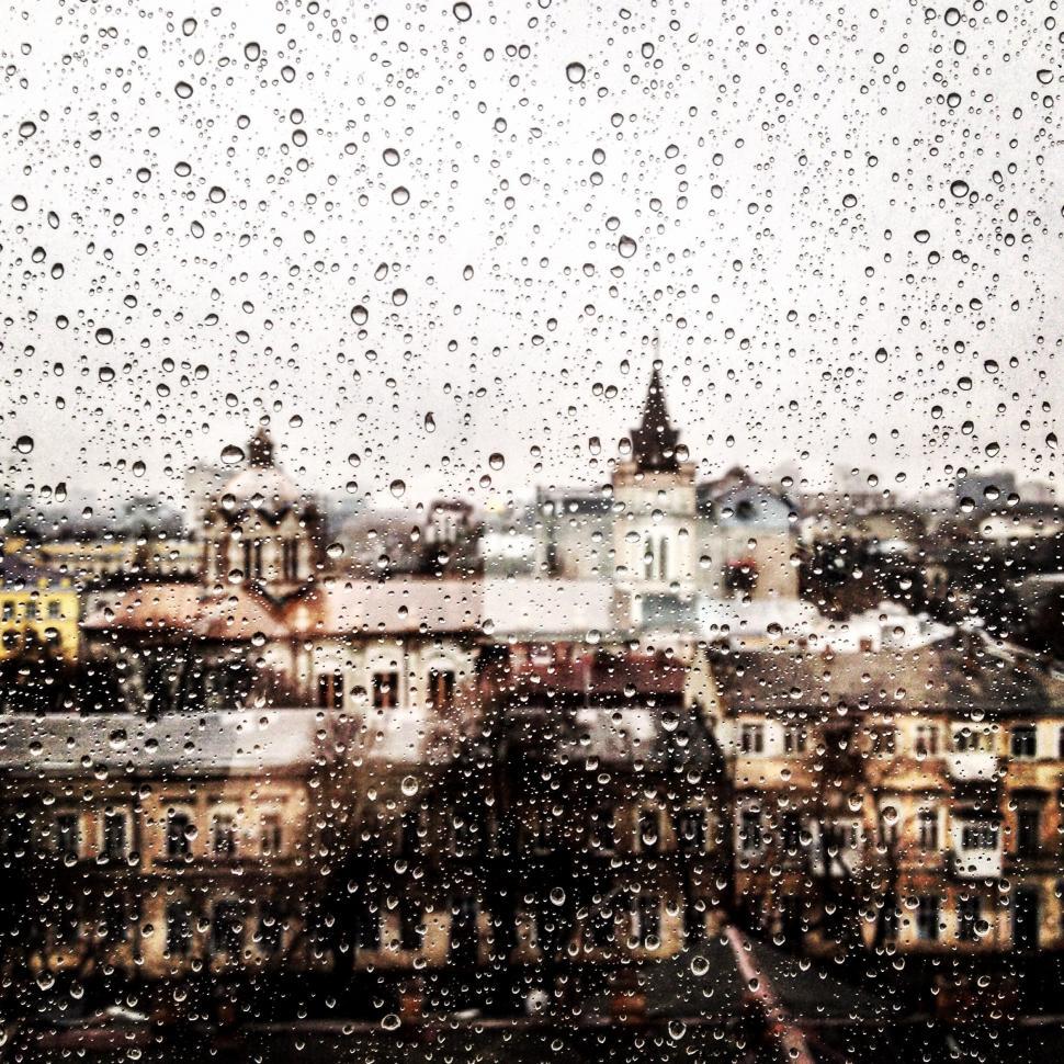Free Image of Rain Drops on a Window With Buildings in the Background 