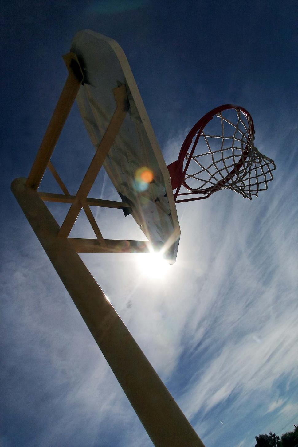 Free Image of basketball hoops net pole sun flare sports backboard basket rim silhouette clouds 