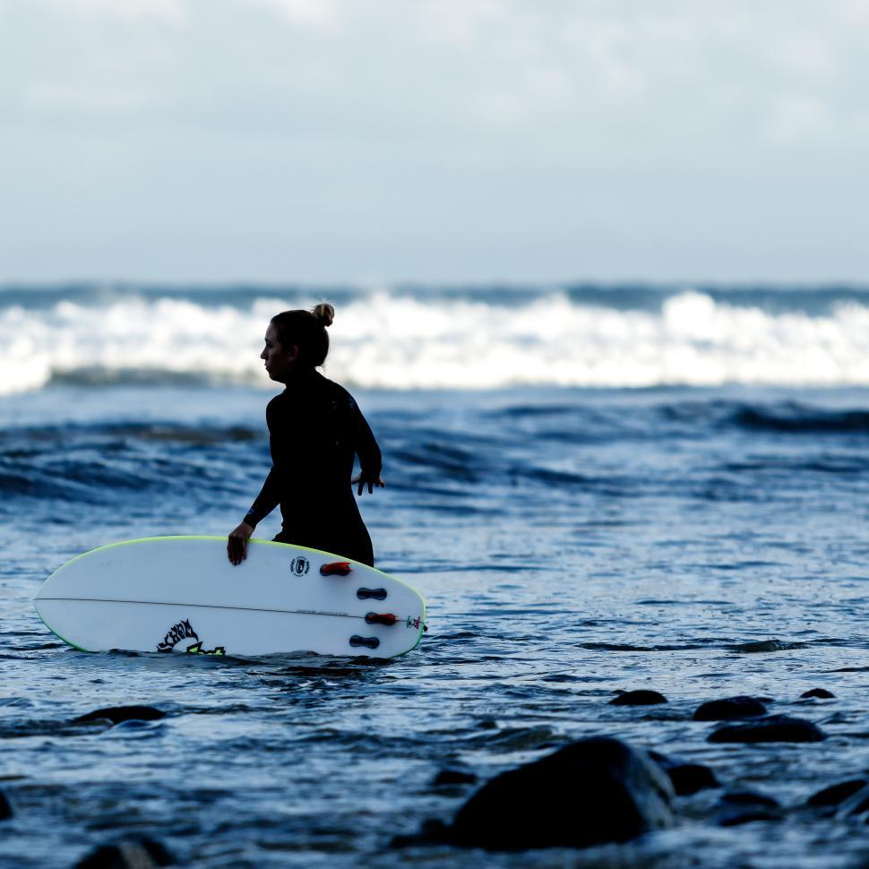 Free Image of Person Walking Into the Ocean With a Surfboard 