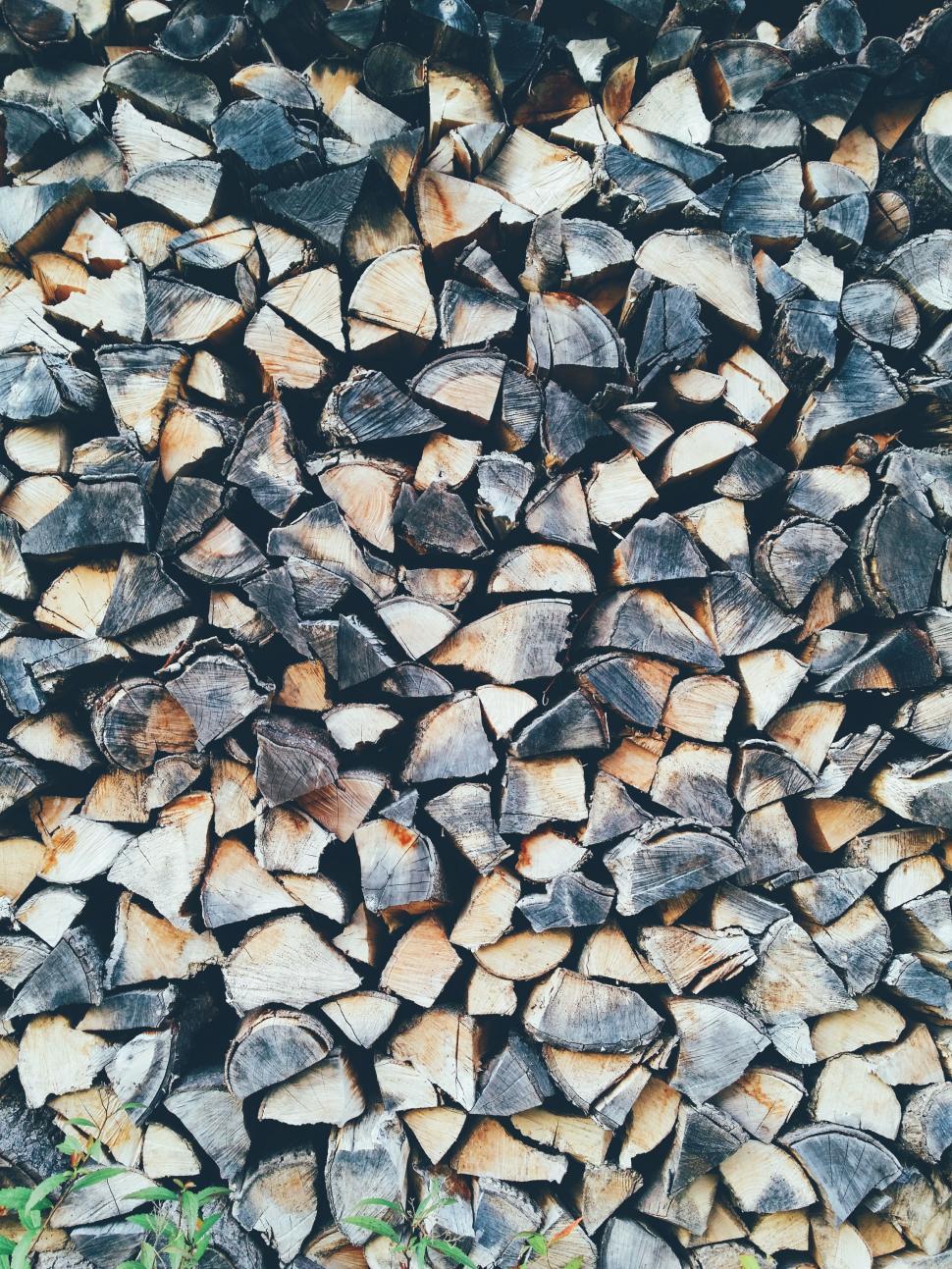Free Image of Large Pile of Wood Next to Green Field 