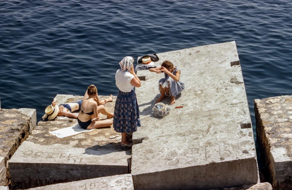 Free Image of Group of People Sitting on the Edge of a Pier 