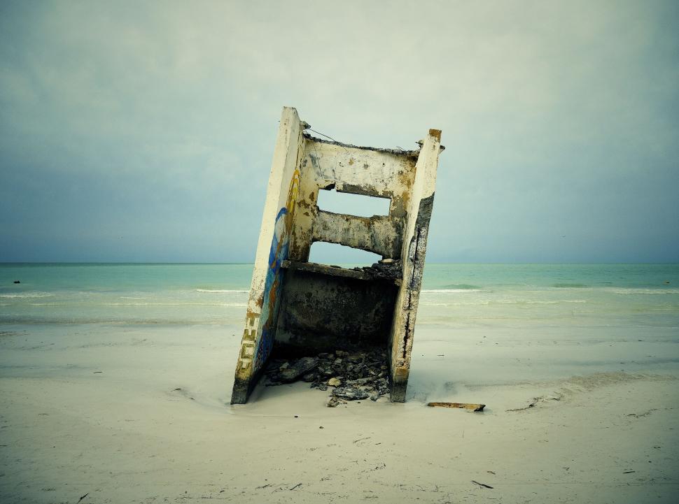 Free Image of Broken Chair on Sandy Beach 