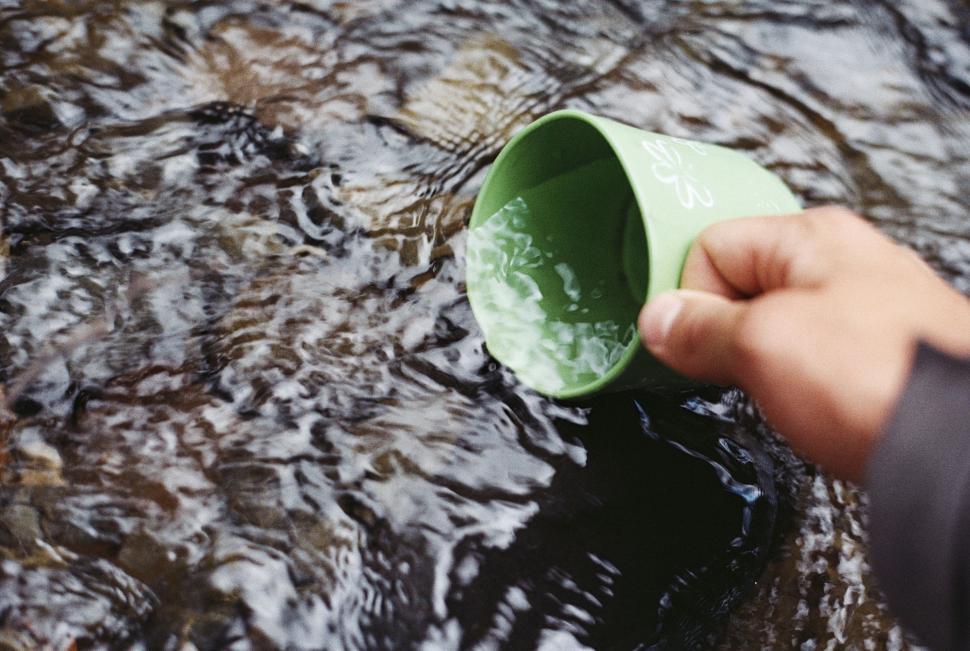 Free Image of Person Holding Green Cup in Water 