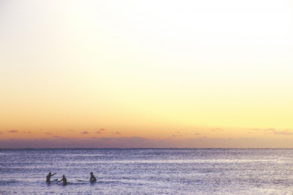 Free Image of Group of People Standing in Ocean at Sunset 