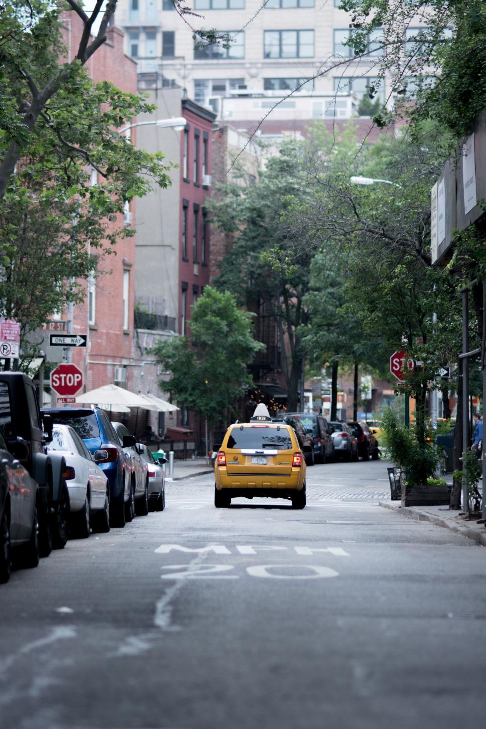 Free Image of Yellow Taxi Cab Driving Down City Street 