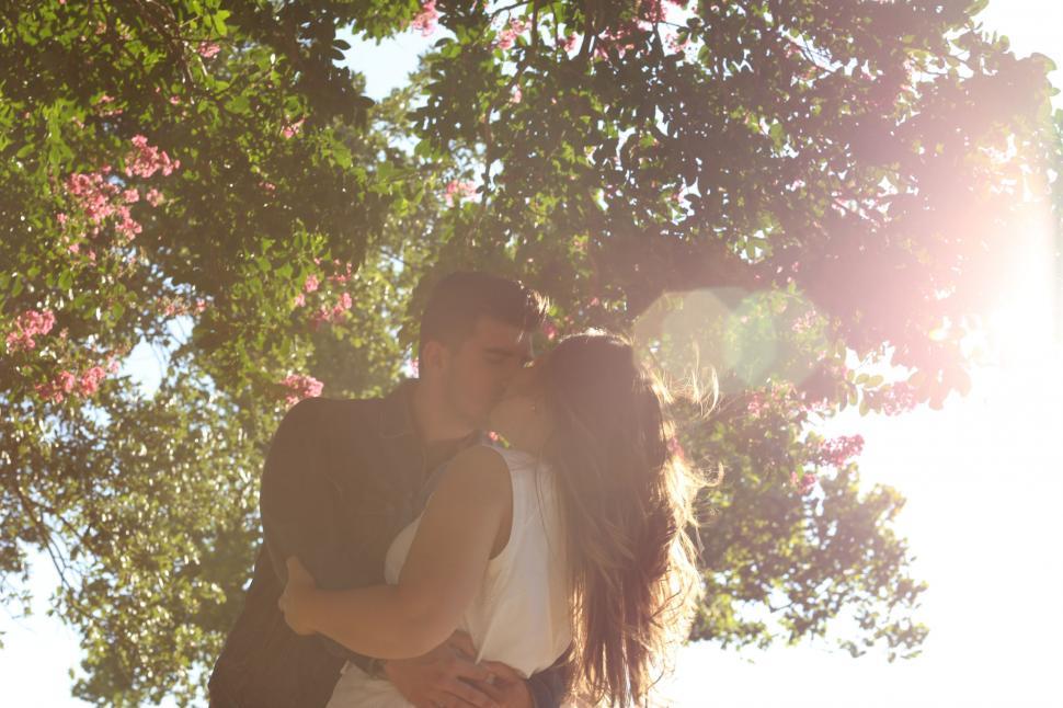 Free Image of Man and Woman Kissing Under Tree 