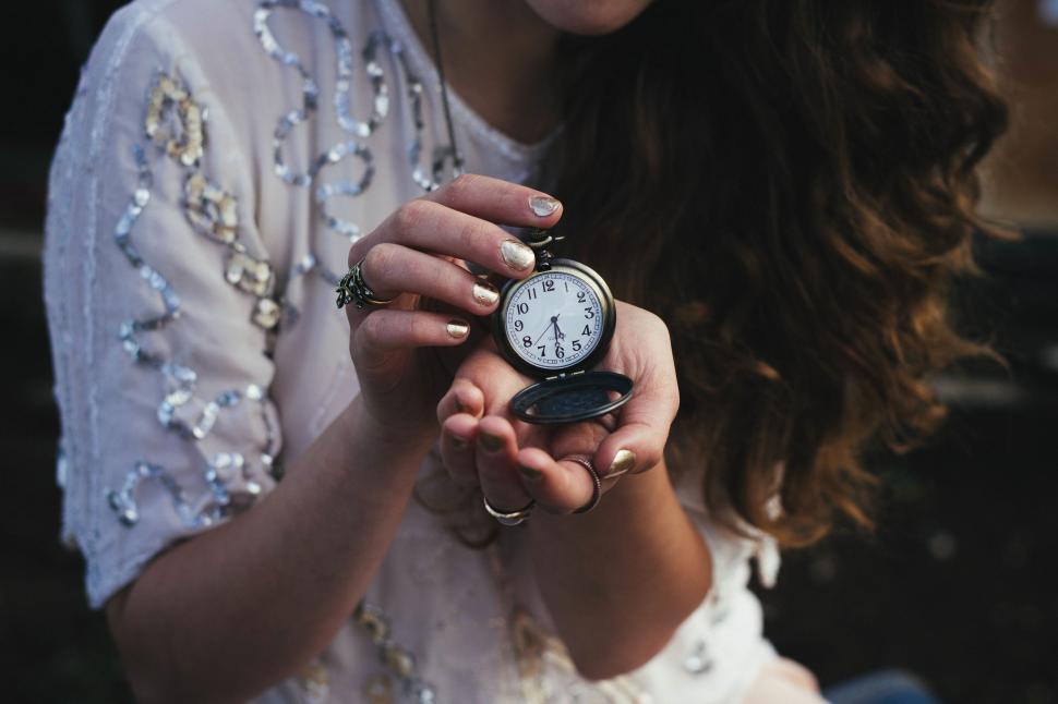 Free Image of Woman Holding Small Clock in Hands 