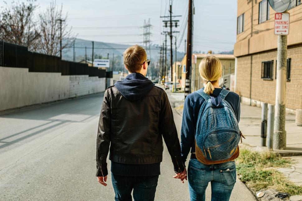 Free Image of A Man and Woman Walking Down a Street Holding Hands 