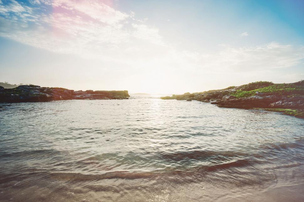Free Image of Sun Shining Over Water at the Beach 