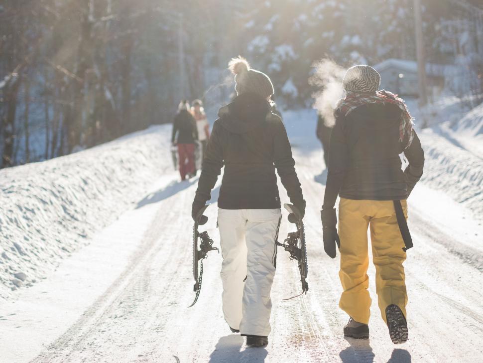 Free Image of Couple Walking Down Snow Covered Road 