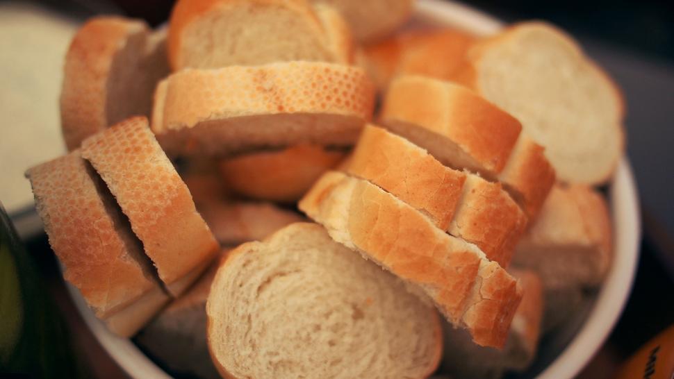 Free Image of White Bowl Filled With Sliced Bread on Table 