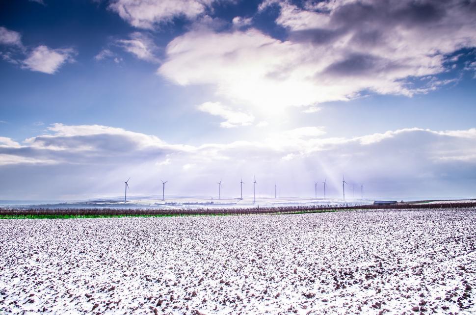 Free Image of Snow-covered Field With Wind Mills in Distance 