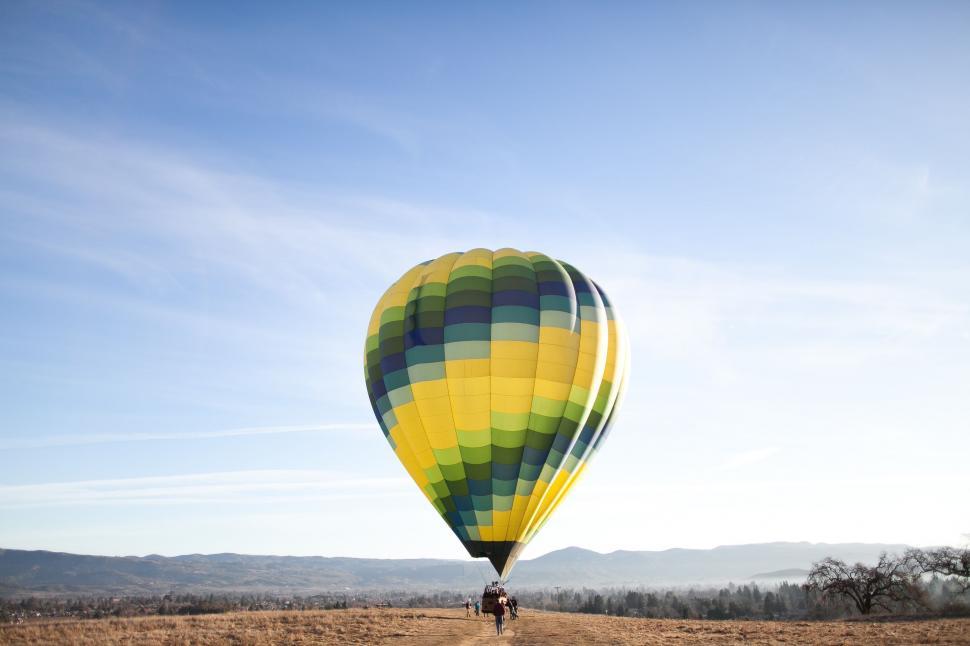 Free Image of Hot Air Balloon Flying Over Dry Grass Field 