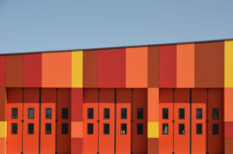Free Image of Row of Orange and Yellow Doors in Front of Building 