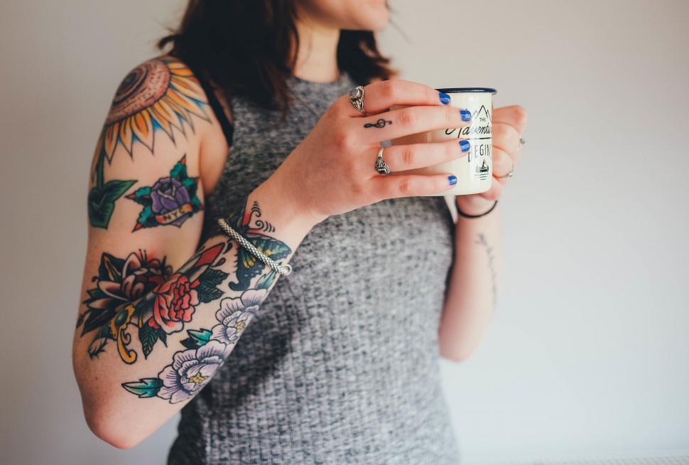 Free Image of Woman With Tattoos Holding a Cup of Coffee 