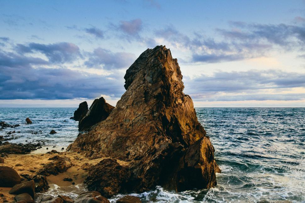 Free Image of Massive Rock Protruding From Ocean Waters 