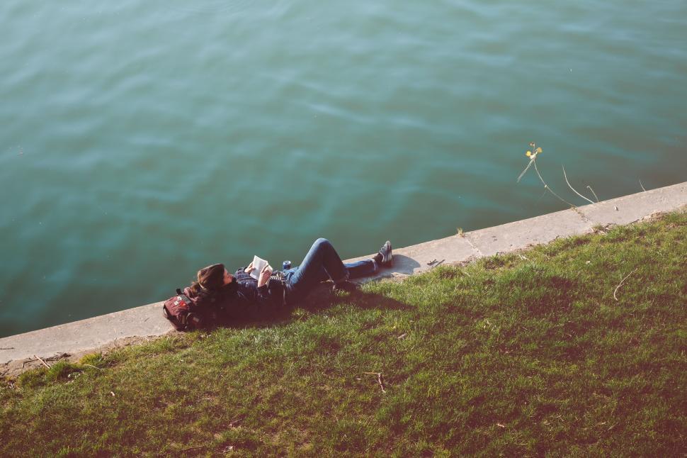 Free Image of Person Laying Beside Body of Water 
