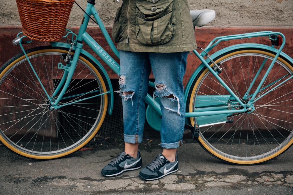 Free Image of Woman Standing Next to Blue Bike 