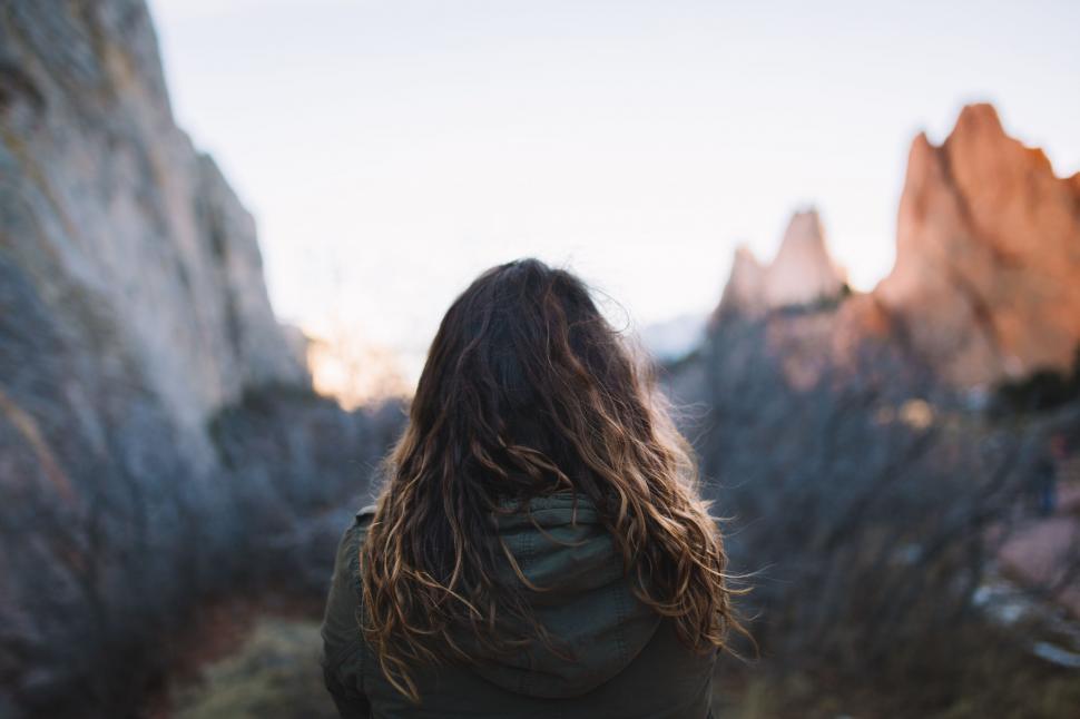 Free Image of Woman With Long Hair Standing in Front of a Mountain 