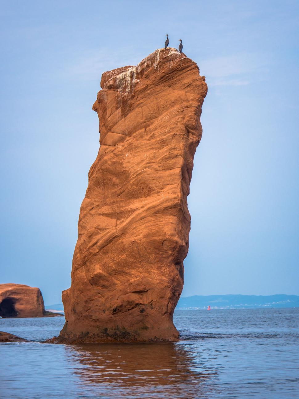 Free Image of Large Rock Jutting Out of Water 