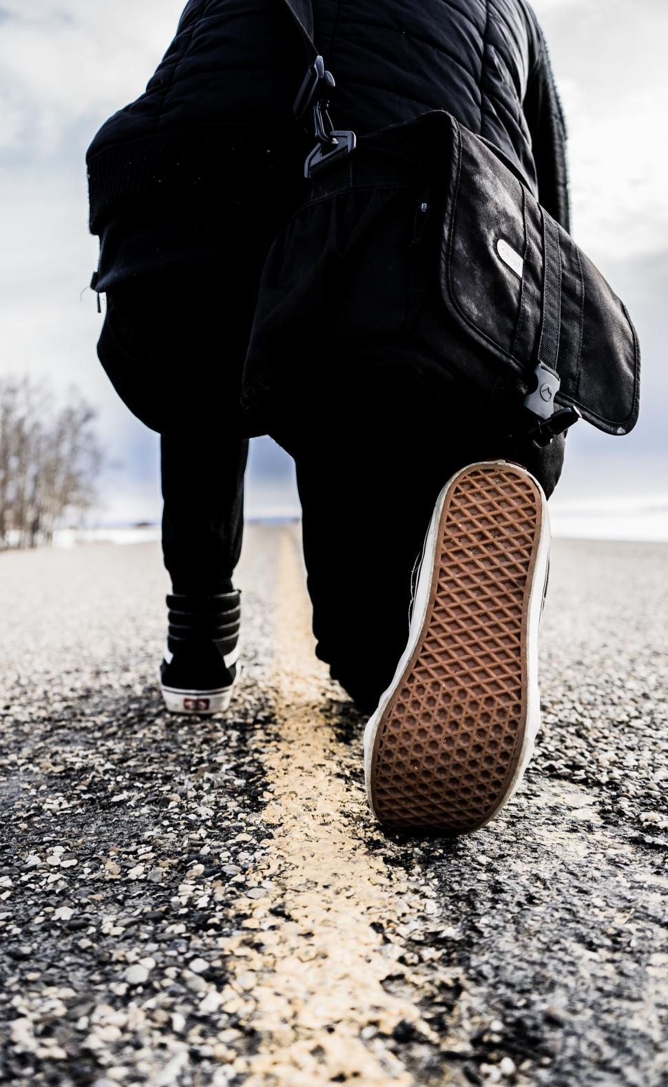 Free Image of Person Walking Down Road With Shoes On 
