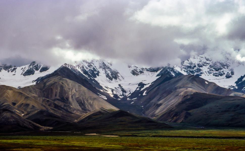 Free Image of Snow-Covered Mountains Shrouded in Clouds 