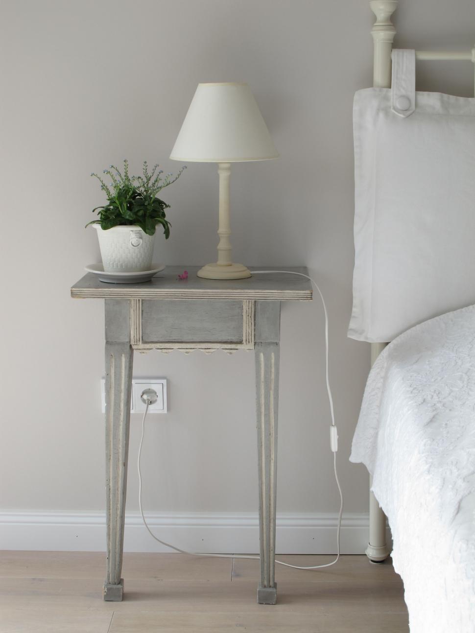 Free Image of Nightstand With Plant Beside Bed 